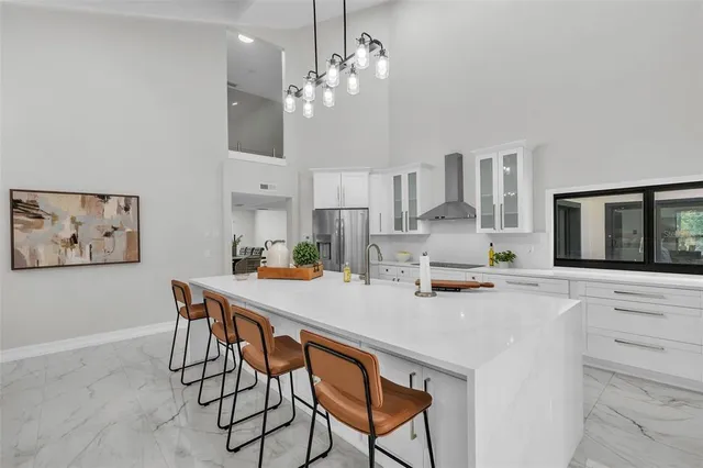 a kitchen with stainless steel appliances a table and chairs in it