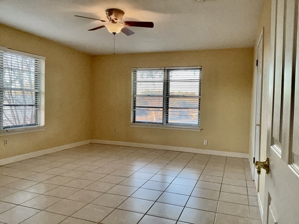 418 Sunset Drive Georgetown, TX 78628 - Photo 14 of 26 Bedroom featuring a ceiling fan, healthy amount of natural light, and light tile patterned floors
