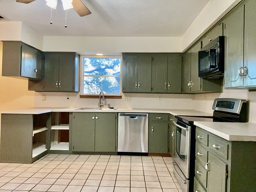 418 Sunset Drive Georgetown, TX 78628 - Photo 7 of 26 Kitchen featuring green cabinetry, stainless steel appliances, light countertops, and a ceiling fan