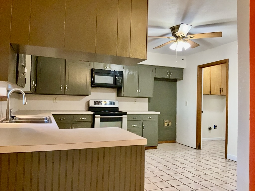 418 Sunset Drive Georgetown, TX 78628 - Photo 8 of 26 Kitchen with stainless steel electric range oven, black microwave, light countertops, green cabinets, and ceiling fan