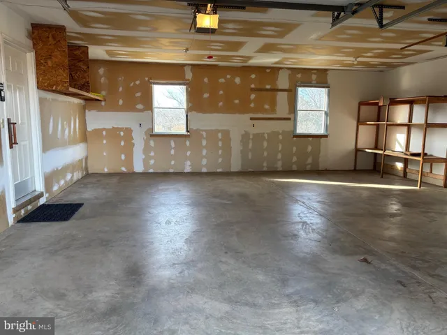a view of a hallway with wooden floor and windows