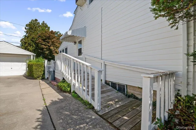 a view of a house with a small yard and wooden floor and fence