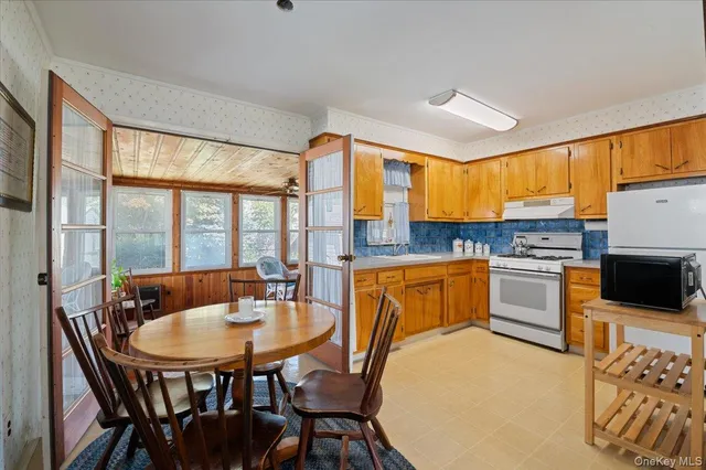 a kitchen with a table chairs sink and cabinets