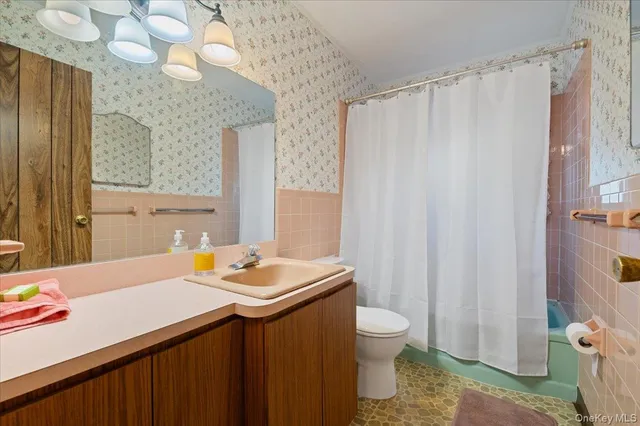 a bathroom with a sink a toilet and shower curtain