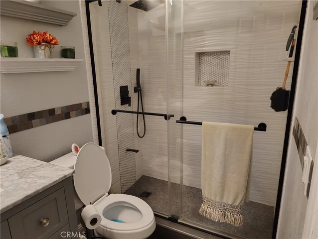 a white toilet sitting next to a bathroom sink and a shower