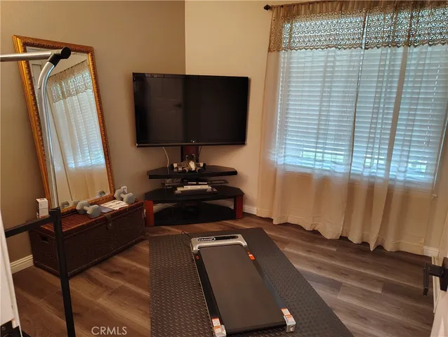 a living room with a bed furniture and a flat screen tv