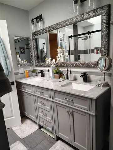 a bathroom with double sink and a mirror