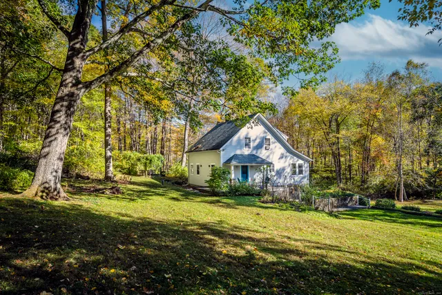 a view of a house with a big yard and large trees