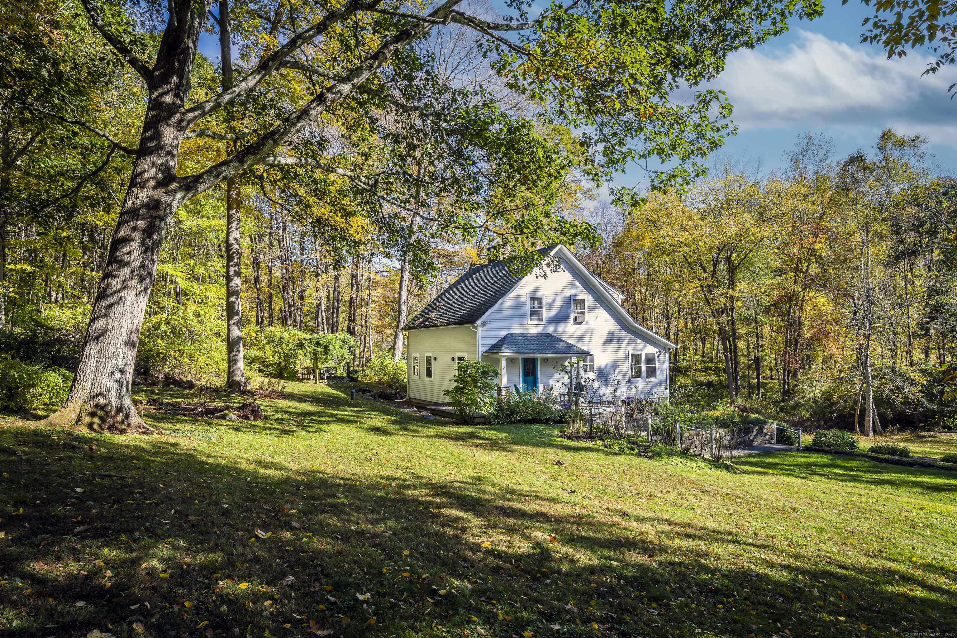 a view of a house with a big yard and large trees