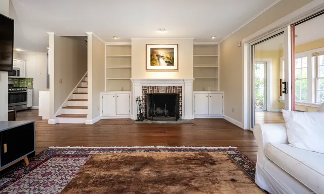a view of a livingroom with wooden floor and a fireplace