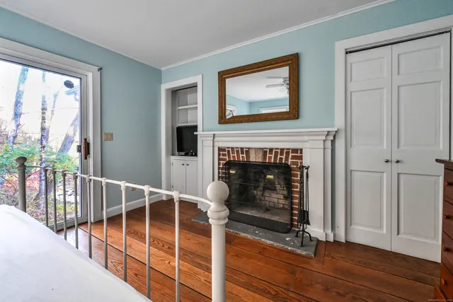 a view of a livingroom with wooden floor and a fireplace