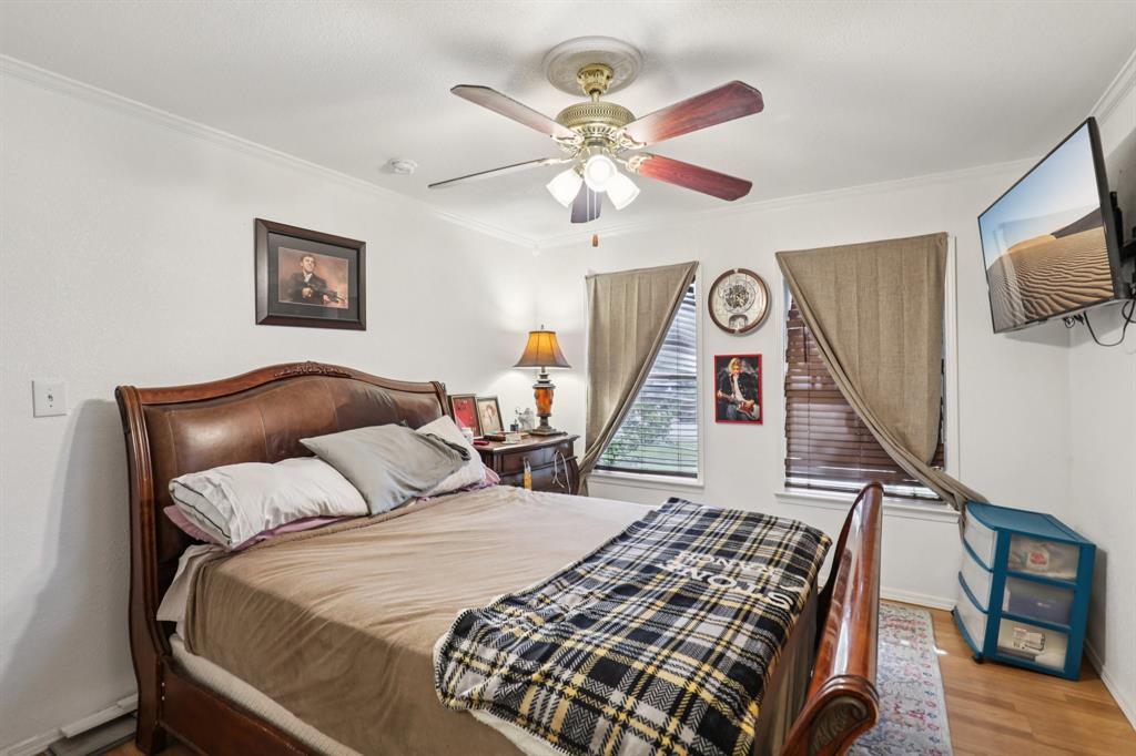 408 Harrison Lane Hurst, TX 76053 - Photo 12 of 15 a bedroom with a bed and a flat tv screen on dresser
