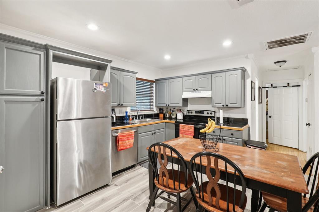 408 Harrison Lane Hurst, TX 76053 - Photo 6 of 15 a kitchen with stainless steel appliances granite countertop a refrigerator a stove a sink a dining table and chairs