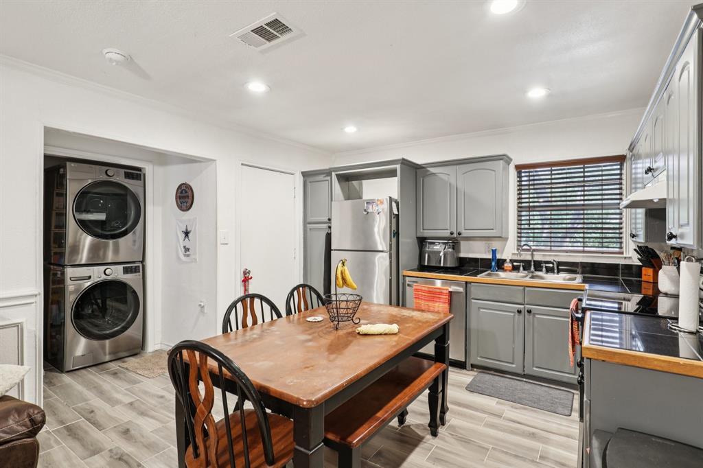 408 Harrison Lane Hurst, TX 76053 - Photo 7 of 15 a kitchen with stainless steel appliances granite countertop a stove top oven a sink a dining table and chairs