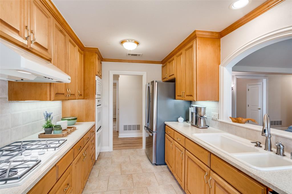 6604 Villa Road Dallas, TX 75252 - Photo 13 of 28 a kitchen with stainless steel appliances kitchen island granite countertop a sink stove and refrigerator