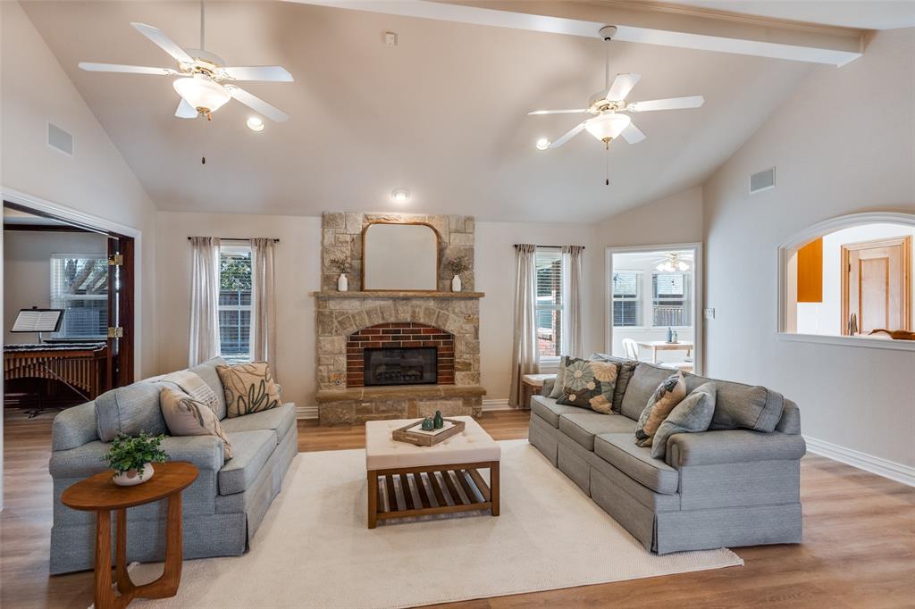6604 Villa Road Dallas, TX 75252 - Photo 7 of 28 a living room with furniture a fireplace and a chandelier