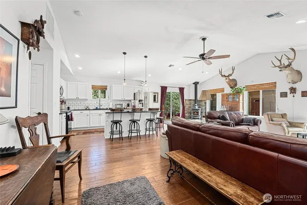 a living room with lots of furniture and view of kitchen