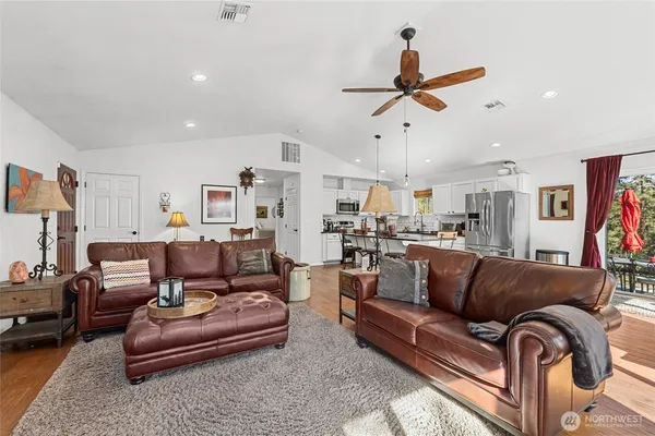 a living room with furniture kitchen view and a chandelier