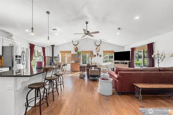 a living room with furniture kitchen view and a large window