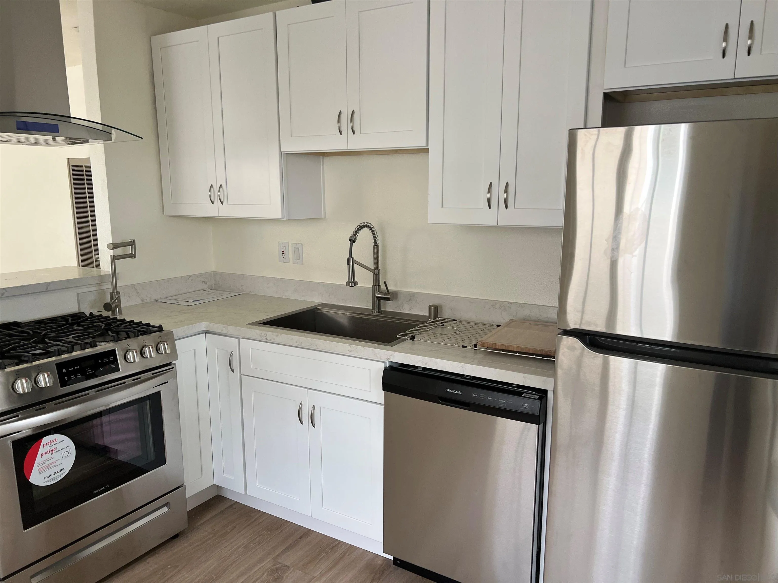 6060 Nancy Drive La Mesa, CA 91942 - Photo 2 of 9 a kitchen with white cabinets and white appliances