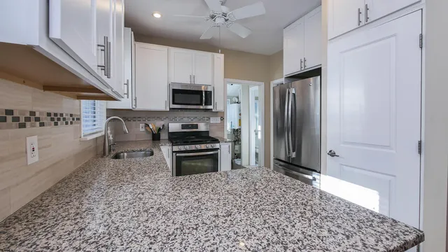a kitchen with stainless steel appliances a stove a microwave and a sink