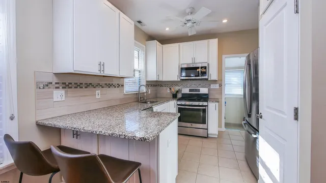 a kitchen with stainless steel appliances granite countertop a stove refrigerator sink and cabinets