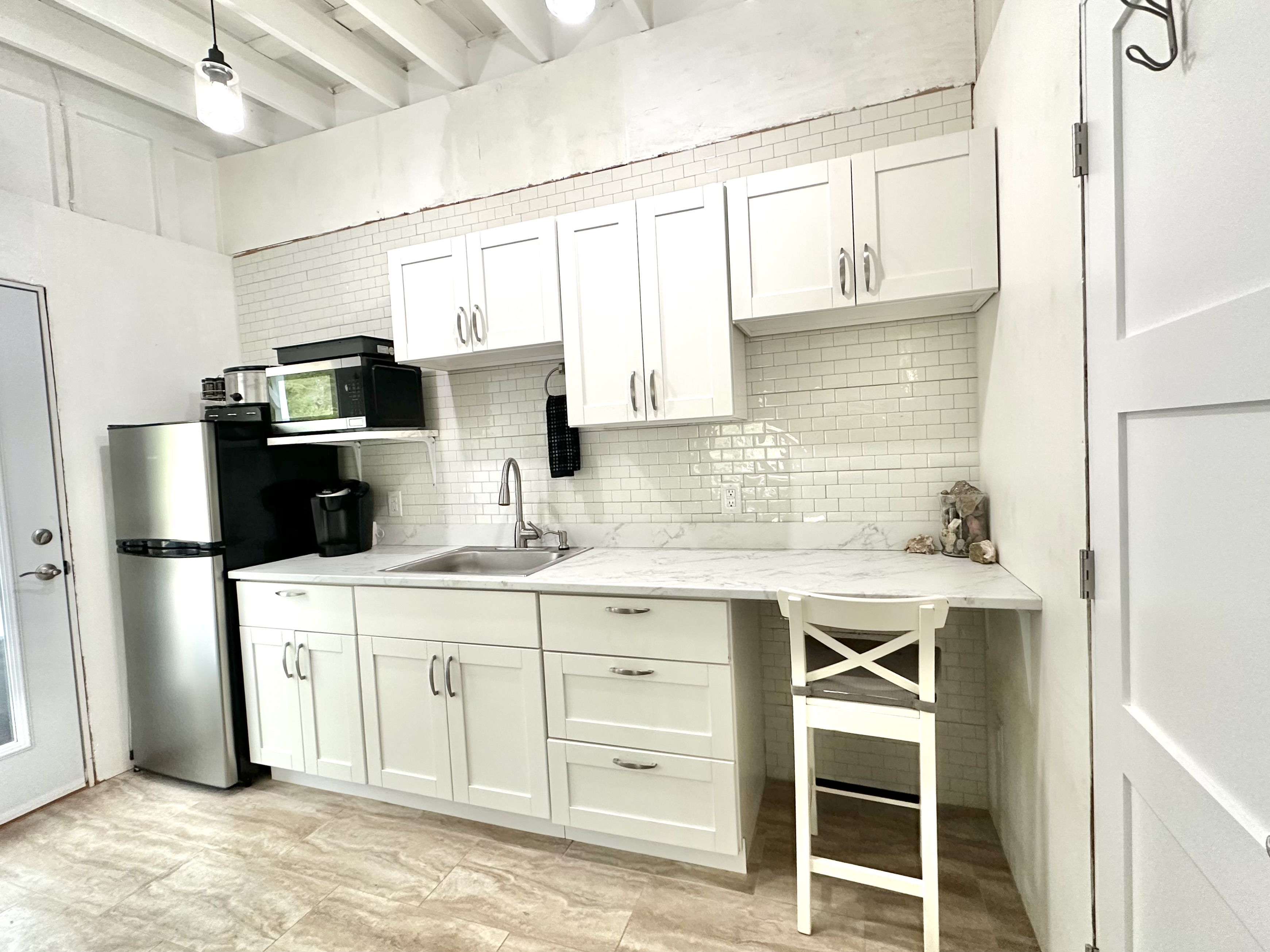 92-2083 Kailua Boulevard Ocean View, HI 96704 - Photo 17 of 30 a kitchen with stainless steel appliances a stove refrigerator sink and cabinets