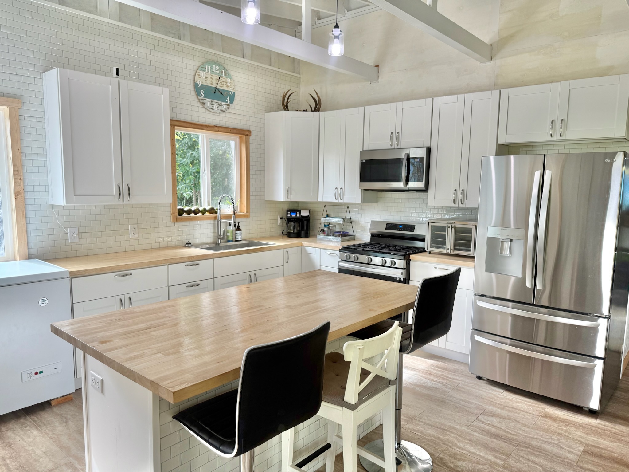 92-2083 Kailua Boulevard Ocean View, HI 96704 - Photo 6 of 30 a kitchen with stainless steel appliances granite countertop a sink stove microwave and refrigerator
