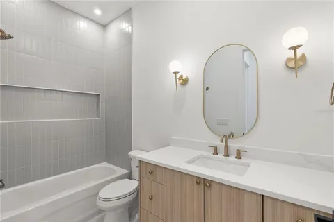 a bathroom with a granite countertop sink a toilet and a mirror