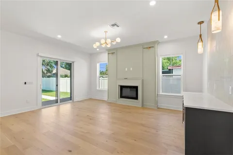 an empty room with windows and fireplace