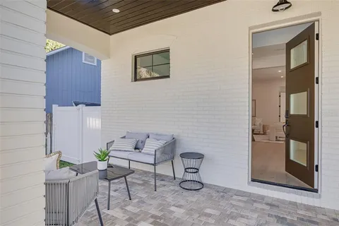 a kitchen with kitchen island a dining table chairs sink and white cabinets