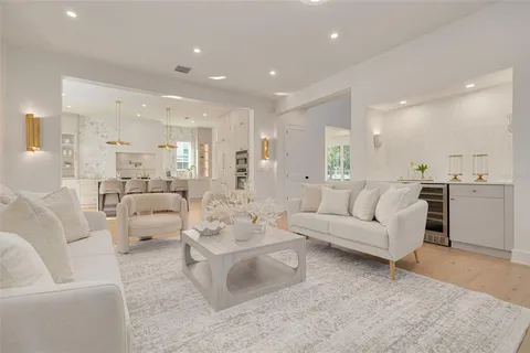 a view of a kitchen with white cabinets and wooden floor