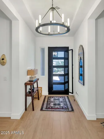 a view of a hallway to a livingroom with furniture and window