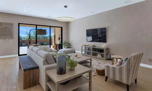 a living room with furniture a flat screen tv and a floor to ceiling window