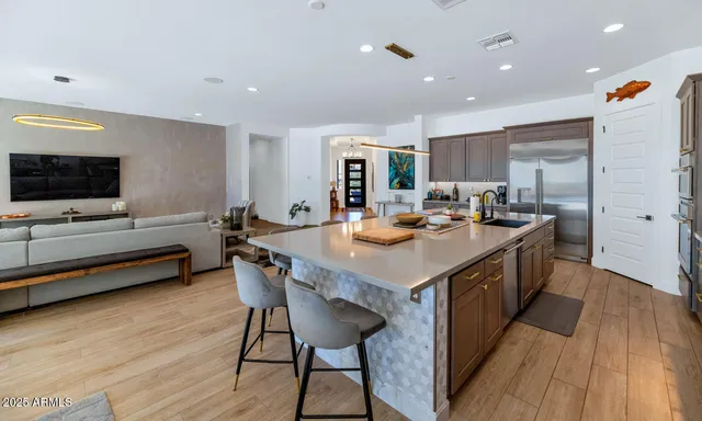 a kitchen with stainless steel appliances granite countertop a sink a stove and a wooden floors