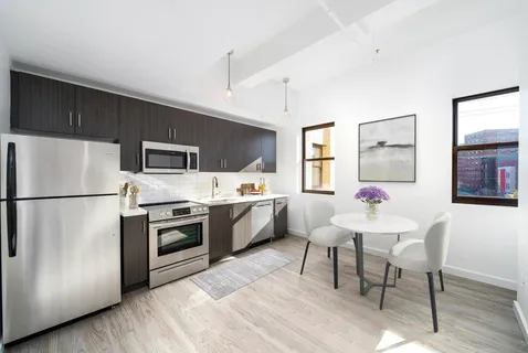 a kitchen with a white refrigerator a dining table and chairs
