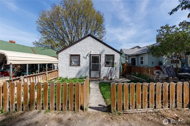 a front view of house yard with wooden fence