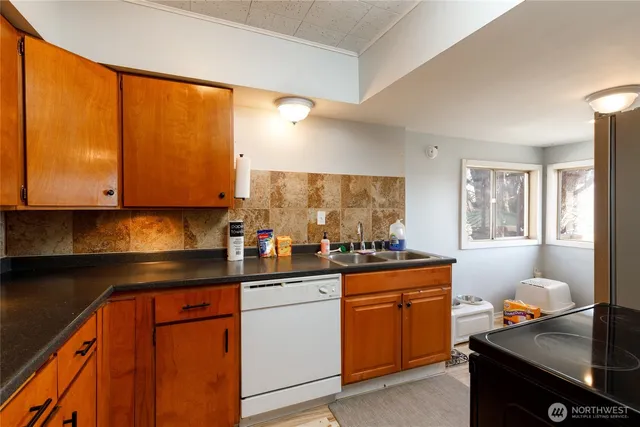 a kitchen with granite countertop a sink stove and cabinets