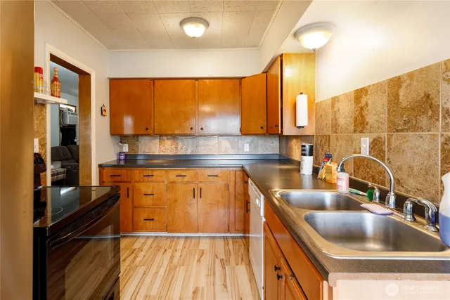 a kitchen with kitchen island granite countertop a sink and a stove
