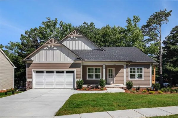 a front view of a house with a yard and trees