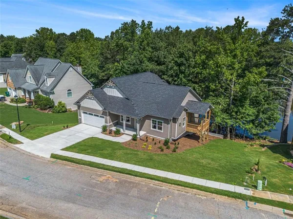 an aerial view of residential houses with outdoor space and trees