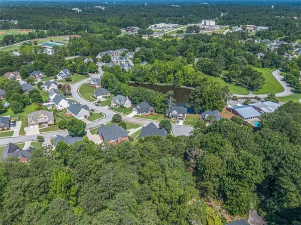 an aerial view of residential houses with outdoor space and trees