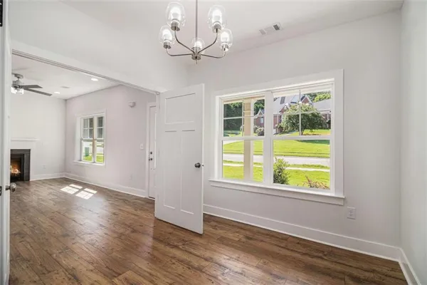 a view of an empty room with a window and wooden floor