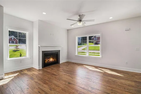 a view of an empty room with a fireplace and a window