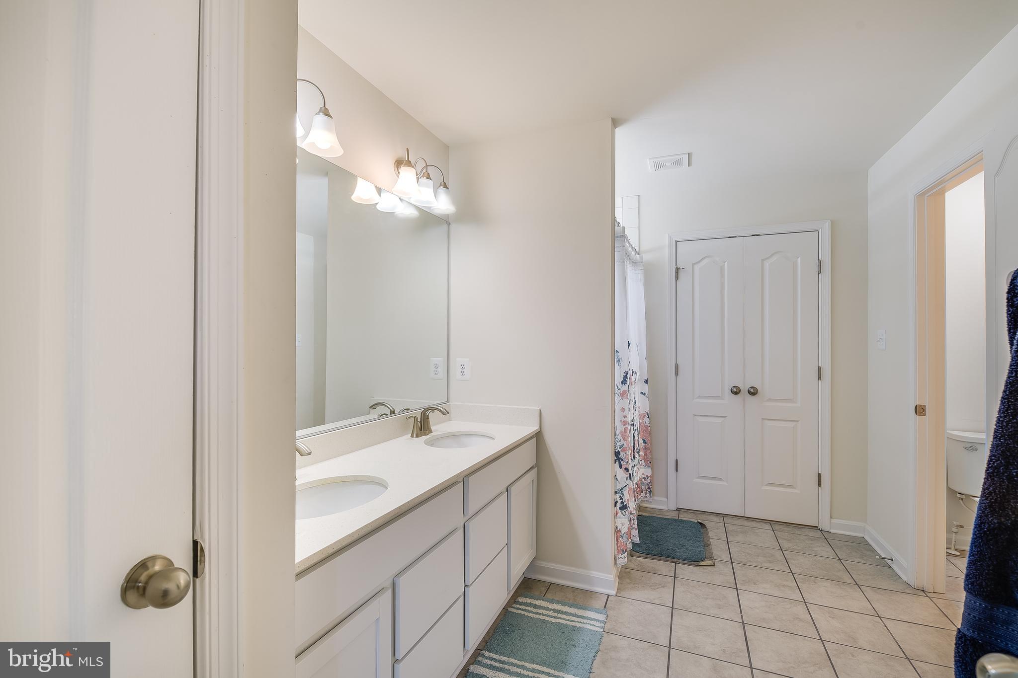 23680 West Patuxent Beach Road California, MD 20619 - Photo 7 of 38 a bathroom with a double vanity sink a mirror and a shower