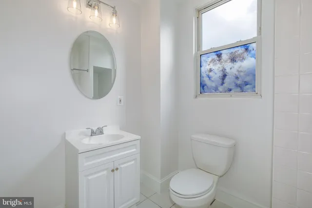 a bathroom with a toilet a sink and mirror