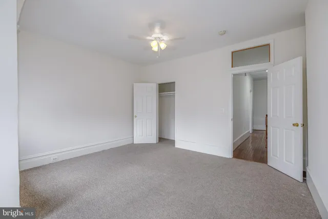 a view of an empty room with a ceiling fan