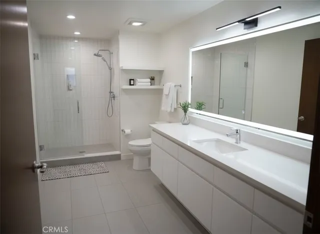 a bathroom with a granite countertop sink mirror and toilet