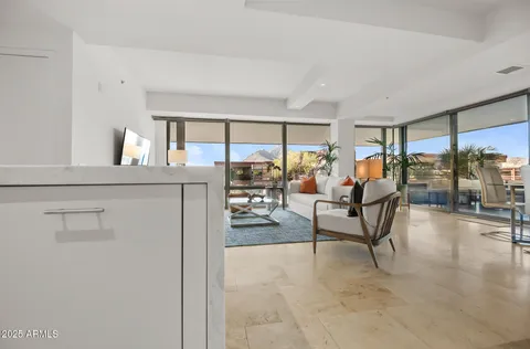 a dining room with glass top table and chairs