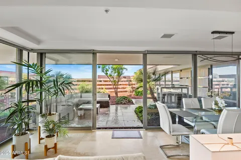 a dining room with furniture water view and large windows